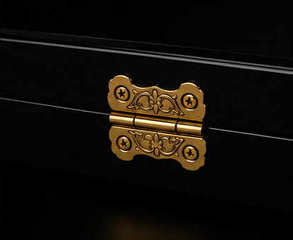 Close-up of ornate gold hinge on black luxury backgammon case